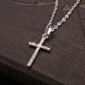 Primo piano di una collana con ciondolo a croce argento intarsiata con zirconi bianchi. - Stile con Intarsio di Strass / Argento