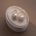 Elegant round pearl ear hook earrings displayed on a luxury plush velvet box detail view - Pink Pearl (1067) / 12mm / Silver