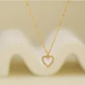 Close-up detail of a minimalist 925 silver heart pendant necklace with shimmering crystals - Gold Style (2)