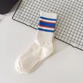 Trendy women's white mid-calf athletic socks featuring blue and red striped ribbed cuffs - One Size / White Blue
