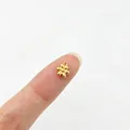 Detaillierte Makroansicht eines kleinen goldenen Blumenanhängers zur Größenreferenz - 4# (Blume)