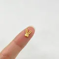 Makroansicht eines winzigen, 18 Karat vergoldeten Edelstahl-Hasenanhängers auf einer Fingerspitze - Hasen Anhänger (2#)