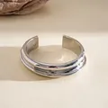 Detail view of a silver minimalist metal cuff bracelet with ribbed geometric texture - Silver