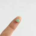 Détail macro d'un petit pendentif pomme verte avec bordure dorée 18K pour bijoux DIY - Bleu clair