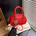 Stilvolle rote Mini-Bowling-Handtasche aus genarbtem Leder mit silbernem Herzanhänger und Gurt - Mit Anhänger / Rot