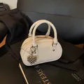 Elegant off-white pebbled leather bowling handbag with a unique silver grape charm detail - With Pendant / Off White