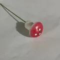 Miniature foam mushroom decoration featuring red cap and white spots on green wire stem - Pink