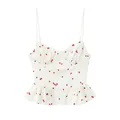 Close-up of a white camisole top featuring a sweet strawberry print and peplum hem. - XS / Tops