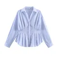 Dettaglio della polo a maniche lunghe azzurra con elegante design a vita a pieghe. - Taglia S / Top / Blu