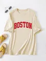 Detailopname van een beige oversized T-shirt met rode Boston-print en zomeraccessoires. - S / Top (3811) / Zandkleur