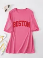 Detail van een roze oversized T-shirt met een gedurfde rode BOSTON grafische print op de borst. - Rozerood