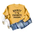 Close-up detail of the 'Hockey Is My Favorite Season' graphic on a yellow sweatshirt. - Yellow (Black Print)