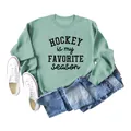 Close-up of mint green sweatshirt with 'Hockey Is My Favorite Season' text - Light Green (Black Print)