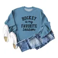 Detail of blue sweatshirt with 'Hockey Is My Favorite Season' text and casual props - Blue (Black Print)