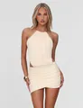 Close-up of elegant cream halter neck top with gold ring and matching ruched mini skirt - White