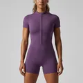 Close-up view of a purple short-sleeve yoga romper with front zipper detail - S / Top And Bottom / Purple Thistle