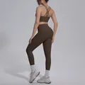 Detailed back view of a dark brown criss-cross back sports bra and high-waisted leggings - Distilled Coffee
