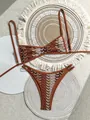 Detail eines Bohemian Häkelbikinis mit Retro-Wellenmuster, präsentiert auf gewebten Matten - S / Oberteil Und Unterteil / Ziegelrot