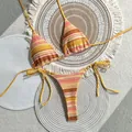 Detailed overhead view of a colorful striped crochet bikini set on rustic woven mats - S / Top And Bottom / Yellow