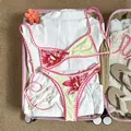 Retro-Bikini-Set mit Blumenmuster und rosa Muschelsaum in einem rosa Reisekoffer - S / Oberteil Und Unterteil / Aprikose