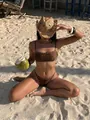 Stylish brown studded bikini set for beach vacation worn by a model sitting on the sand - S / Top And Bottom / Brown