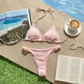 Primer plano de un conjunto de bikini rosa con bordado floral junto a una piscina - S / Top Y Pantalón / Rosa
