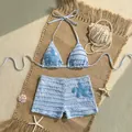 Vue détaillée d'un bikini bleu clair deux pièces avec étoiles de mer et short sur tapis - Bleu
