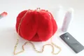 Vibrant red faux fur plush handbag featuring a gold chain strap and clasp closure - Red