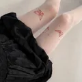 Primer plano de medias blancas con tatuaje, elegantes mariposas rojas y motivos de estrellas. - Talla única / Mariposa Estampada Café (Parte Inferior) / Blanco