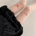 Close-up view of white tattoo tights featuring elegant red butterfly prints and stars. - One Size / Coffee Printed Butterfly (Bottom) / White