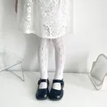 Close-up view of white floral jacquard mesh tights for girls in minimalist white setting - Ages 8-10 / Daisy Flower Style / White