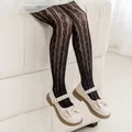 Close-up of girls black mesh tights with heart pattern and cream Mary Jane shoes - Ages 8-10 / Small Heart Vertical Stripe Style / Black