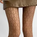 Close-up of brown rhombus pattern hollowed-out lace tights worn with a leather skirt - One Size / Retro Diamond Pattern / Brown