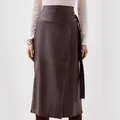 Detailansicht eines eleganten braunen PU-Lederrocks mit unregelmäßigem Schlitz und Taillengürtel - S / Unterteile / Dunkelbraun