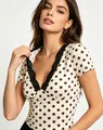 Close-up of V-neck polka dot T-shirt with delicate black lace trim detailing - S / Tops / Apricot
