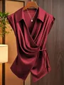 Detail view of a burgundy satin wrap blouse with a waist tie and silk-like texture. - S / Tops / Burgundy