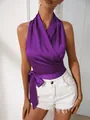 Vista detallada de un top de satén morado con cuello halter, lazo lateral y diseño cruzado. - S / Tops / Púrpura