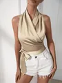 Detalle de la parte superior halter de satén champán con el elegante lazo en la cintura. - L / Tops / Champán