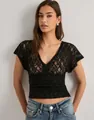 Detailed view of the sheer black floral lace short sleeve top for women in Y2K style. - S / Tops / Black