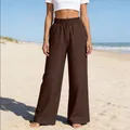 Detailansicht einer dunkelbraunen, hoch taillierten weiten Hose am Strandhintergrund - Dunkelbraun