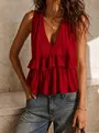 Primo piano di un elegante top smanicato rosso con scollo a V e balze strutturate - Rosso