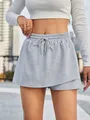 Detailed view of gray sporty drawstring skort featuring a layered skirt-over-shorts design - S / Bottoms / Gray