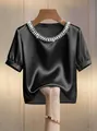 Detail eines eleganten schwarzen Satins-T-Shirts mit doppellagigem Perlenausschnitt - S / Oberteile / Schwarz