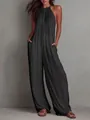 Detailed view of a chic black pleated halter-neck wide-leg jumpsuit on a model for vacation - S / Top And Bottom / Black