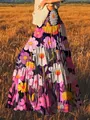 Bohemian maxi-rok met levendige olieverf bloemenprints in een gouden veldomgeving. - Roze