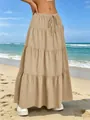 Dettaglio di una gonna maxi beige a balze con coulisse in vita e tessuto plissettato in spiaggia - Kaki