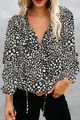 Close-up detail of women's leopard print V-neck shirt featuring ruffle cuffs and ties - S / Tops / Black