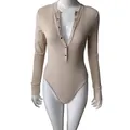 Close-up detail of ribbed fabric and button neckline on beige long sleeve bodysuit. - S / Tops / Apricot