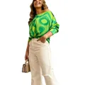 Full-body view of woman in green geometric print long-sleeved top and beige pants. - S / Tops / Green Circles