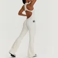 White backless yoga jumpsuit featuring functional side pockets and flattering flared leg design - S / Tops / Ivory